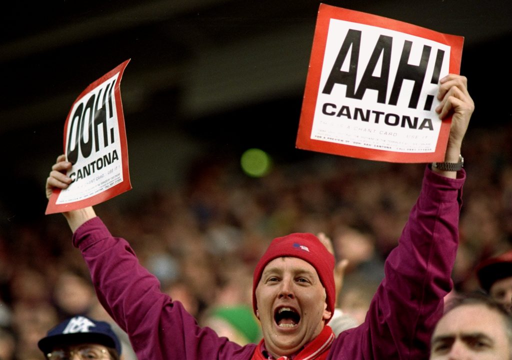 Un tifoso con i cartelli di "AAH CANTONA"