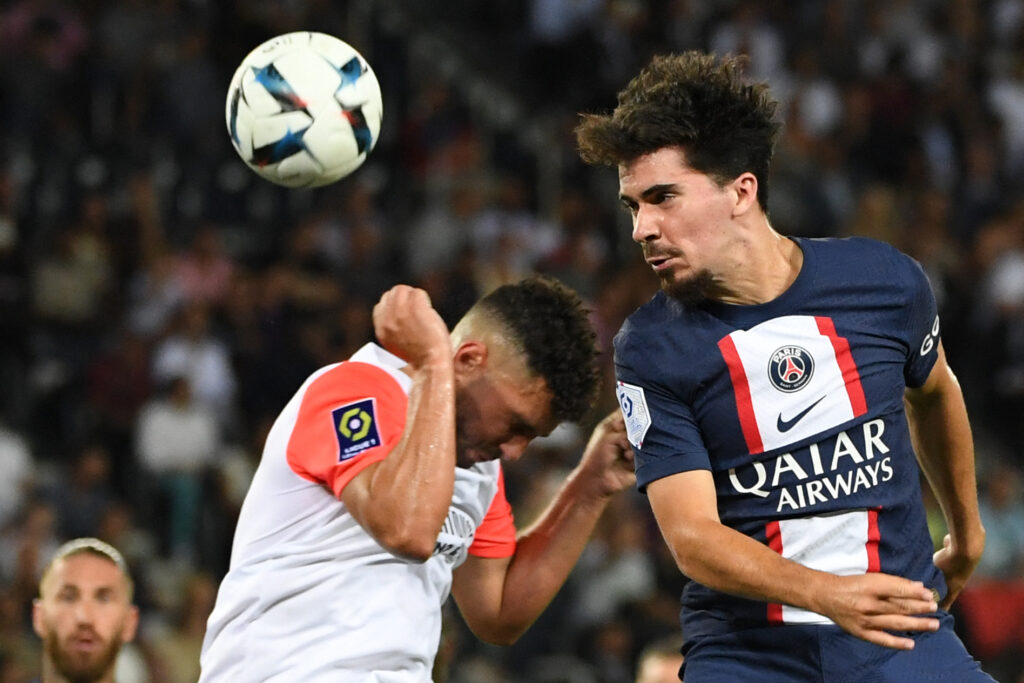 Primo piano di Vitinha in un duello aereo con la maglia del PSG